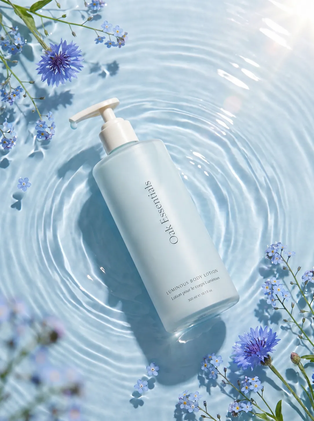 Blue body lotion pump bottle floating in water with cornflowers, body care lifestyle photography