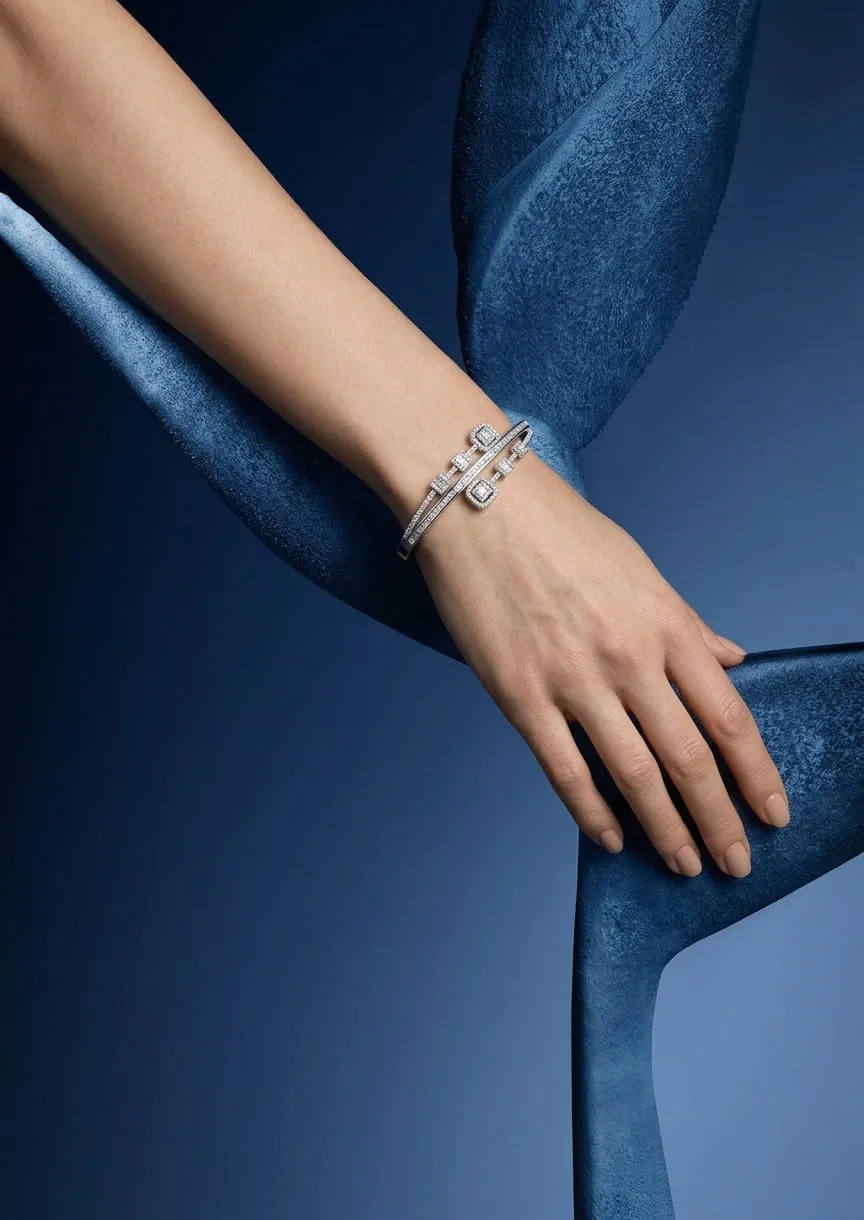 Close-up of a hand wearing a diamond bangle resting on a blue sculpture