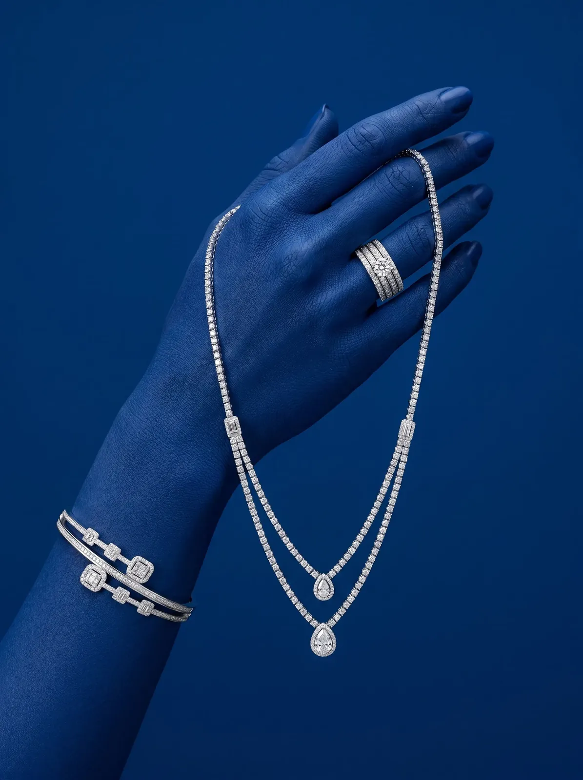 Diamond ring, necklace and bracelet displayed on a sculpted blue hand